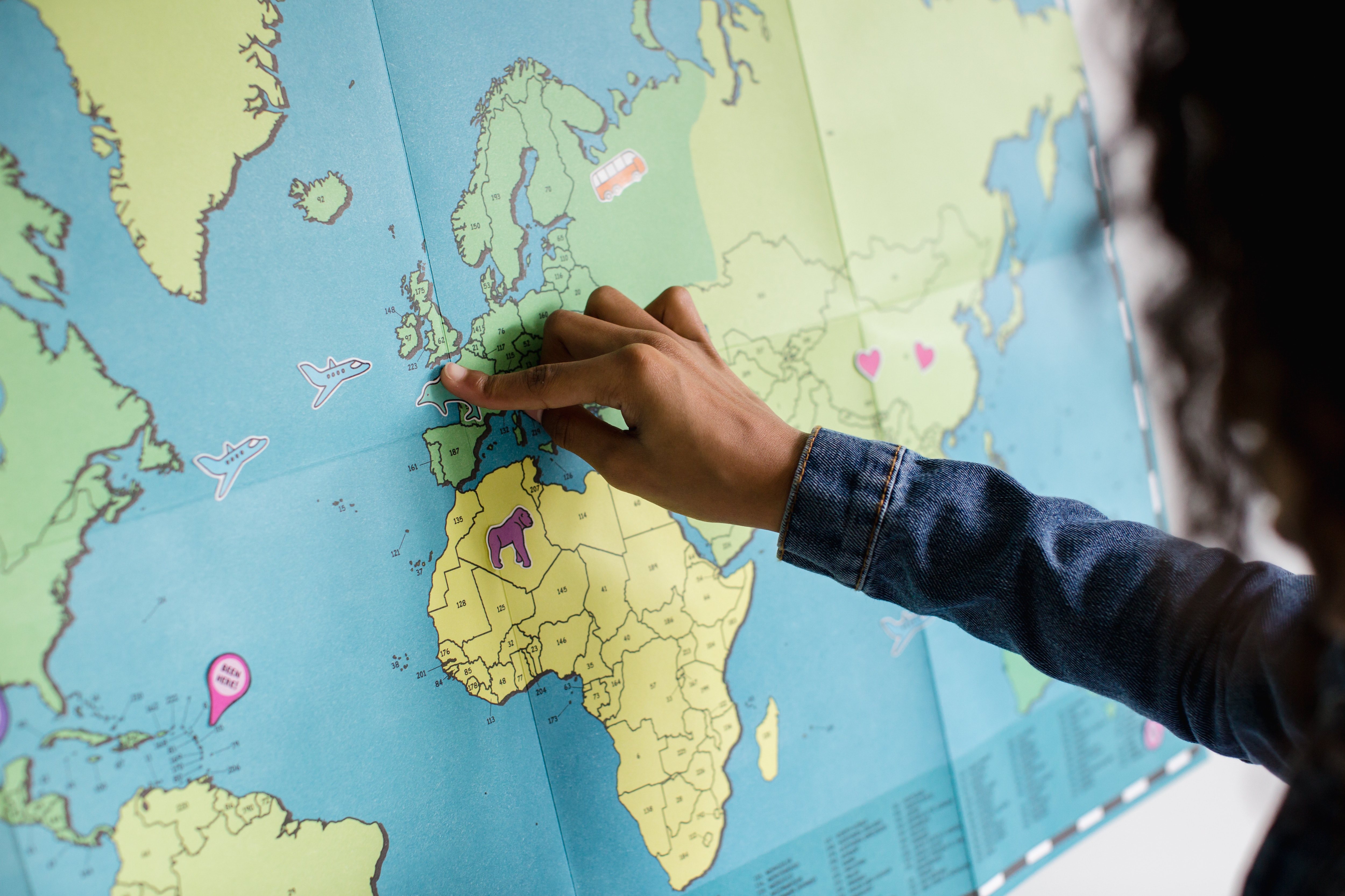 person putting a pin on a world map