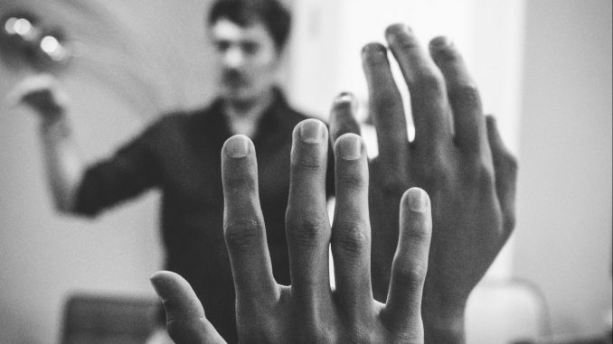 Close up of two raised hands in an audience