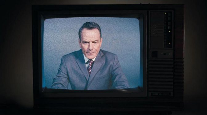 Bryan Cranston in a suit on a fuzzy retro TV screen looking serious