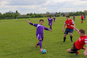 Man of the match Tom Morris (red) puts in a slide tackle on BSc captain Nick Burgess