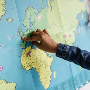 person putting a pin on a world map