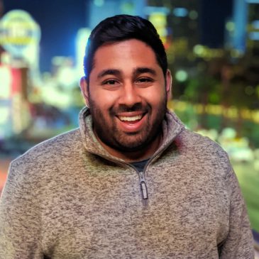 omar smiling in front of a night-time backdrop