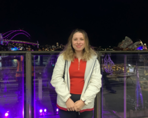 Emily in Sydney, in front of the harbour at night.