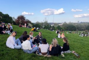 A group of students on Primrose Hill, with a view of London in the background