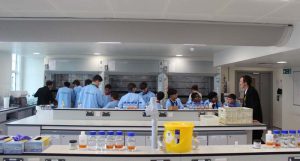 Image of a group of people standing in a lab in safety clothes.